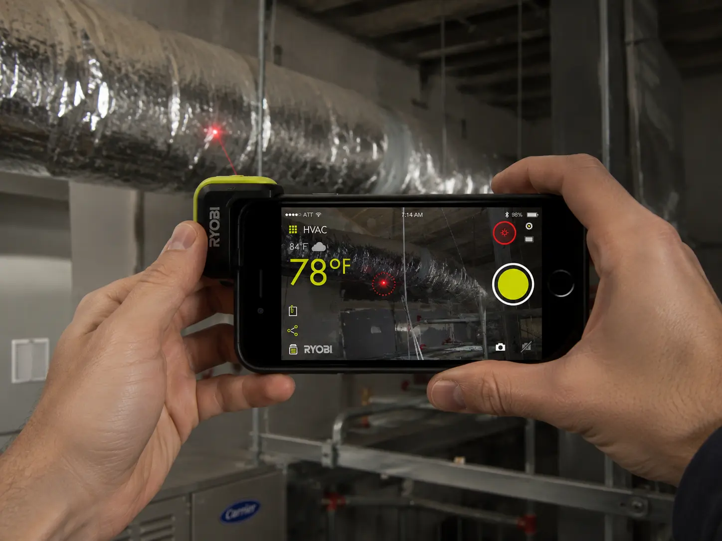 The infrared thermometer tracks surface temperature live over the camera view while inspecting HVAC ducting.