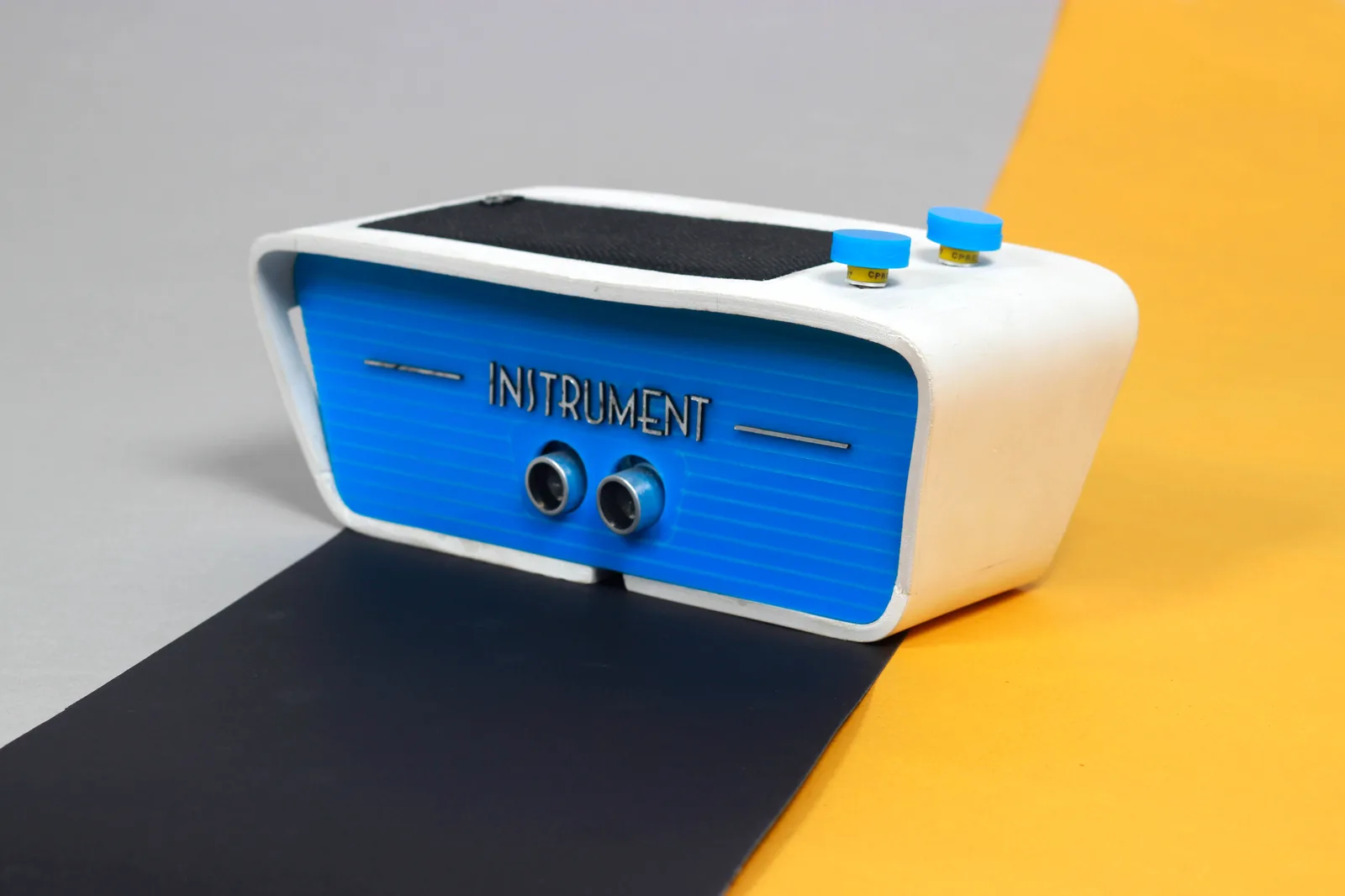 The Instrument, a 3D-printed enclosure with two ultrasonic sensors on the face and knobs for switching modes.